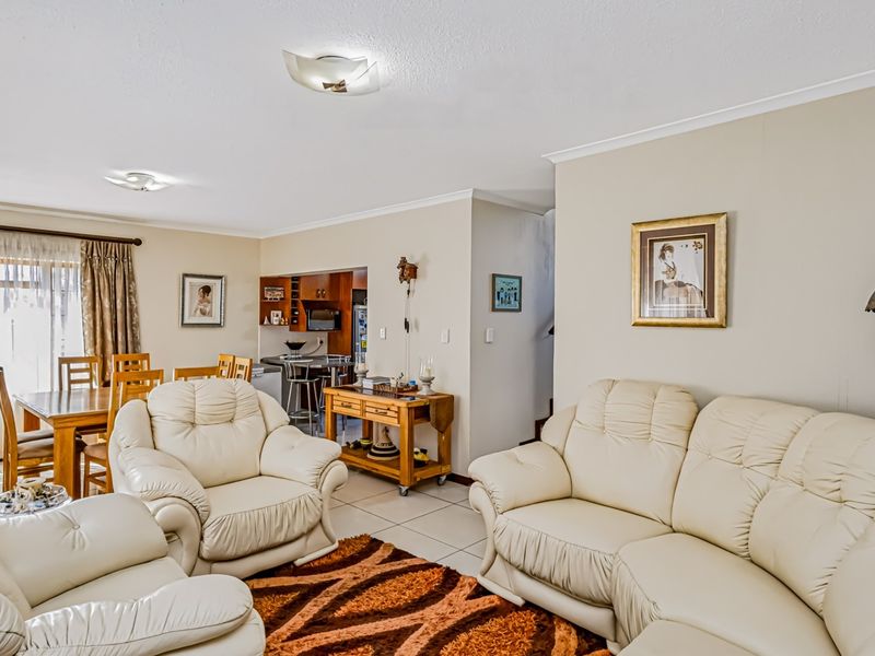 Spacious open-plan living and dining area featuring tiled flooring, neutral walls, and a seamless flow into the adjacent kitchen space.