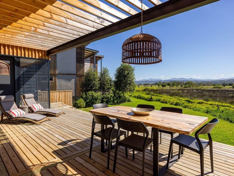 Spacious timber deck featuring a pergola, integrated lighting, and scenic views over the surrounding landscape.