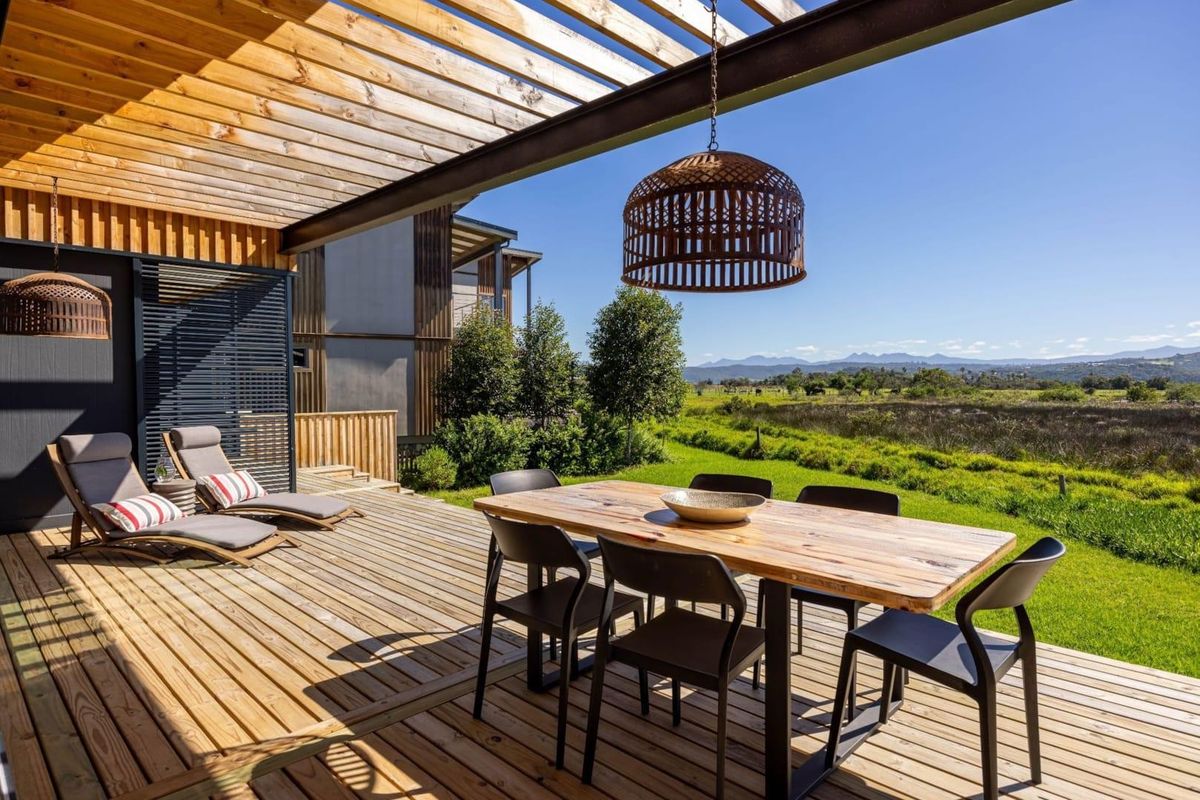 Spacious timber deck featuring a pergola, integrated lighting, and scenic views over the surrounding landscape.