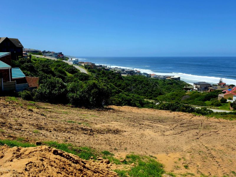 A scenic view overlooking the coastline and ocean from a vacant residential plot.
