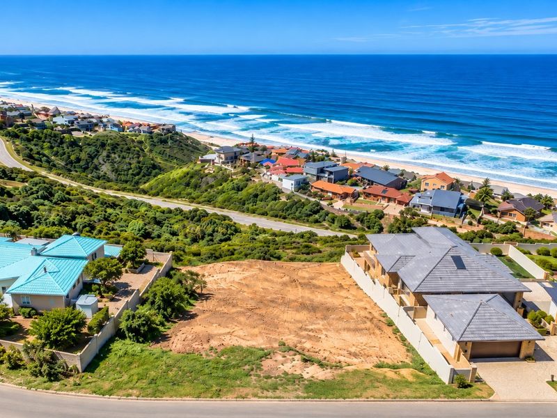 Aerial view of a vacant residential plot situated in a coastal neighborhood, featuring established boundary walls and proximity to the ocean.