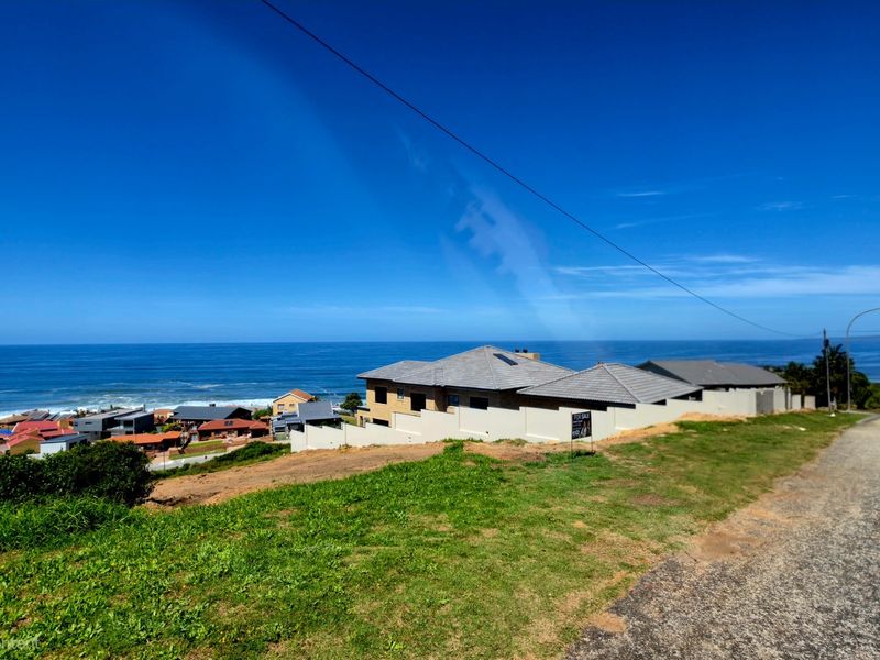A scenic elevated view overlooking the coastal landscape and ocean, showcasing the surrounding residential neighborhood and horizon.