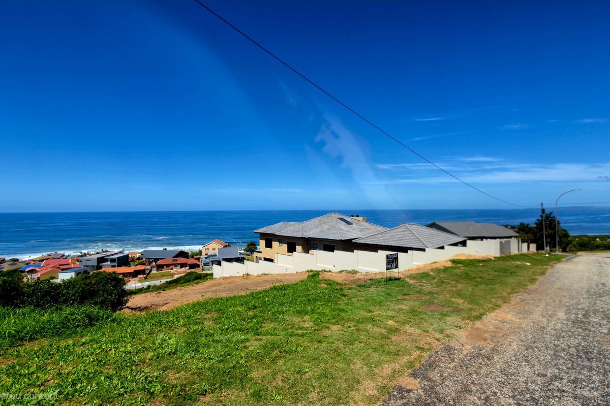 A scenic elevated view overlooking the coastal landscape and ocean, showcasing the surrounding residential neighborhood and horizon.