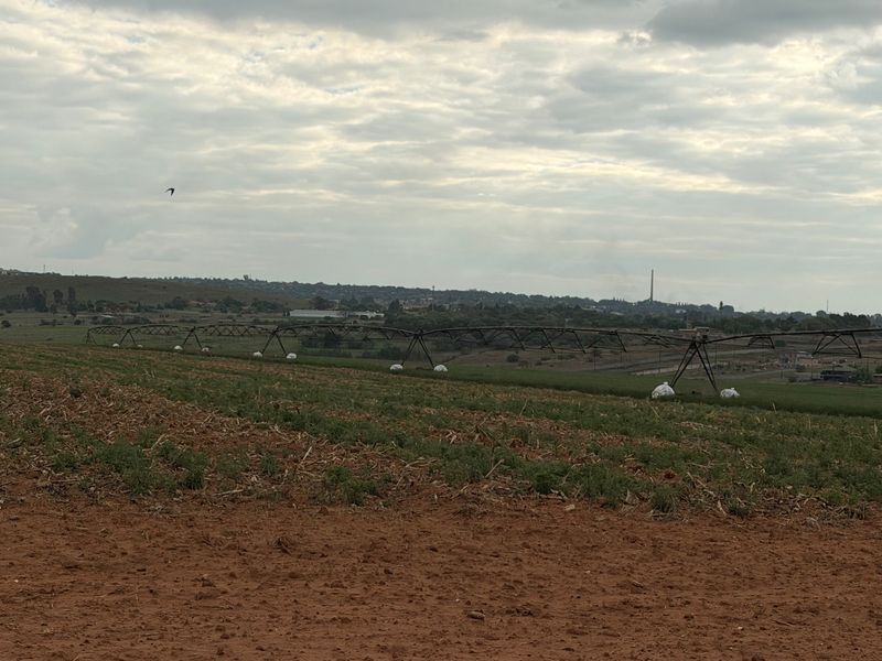 A wide view of the farm landscape featuring a large-scale center pivot irrigation system spanning across the cultivated fields.