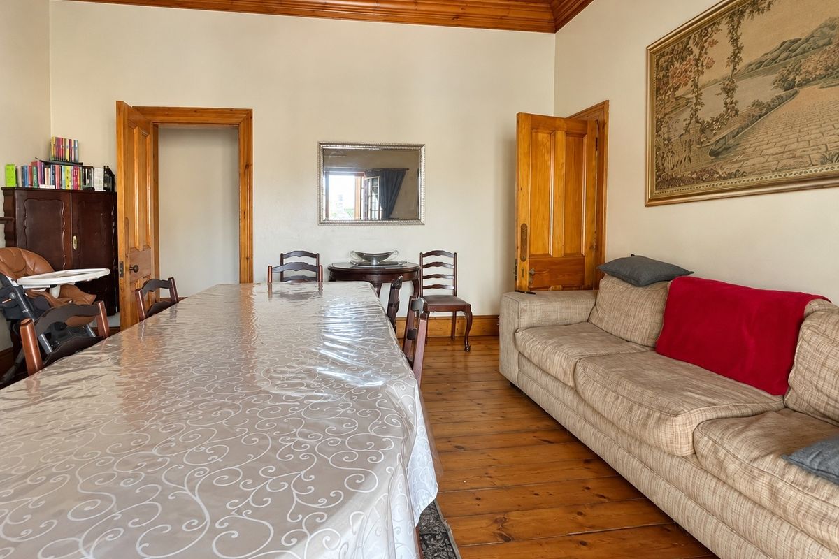 Spacious living area featuring original timber flooring, high timber ceilings, and classic wooden door frames, offering a warm and traditional aesthetic.