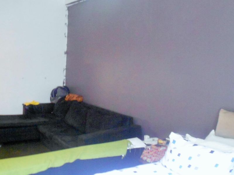 An open-plan living area featuring a dark accent wall with visible unfinished edges, requiring cosmetic attention to improve the overall aesthetic.