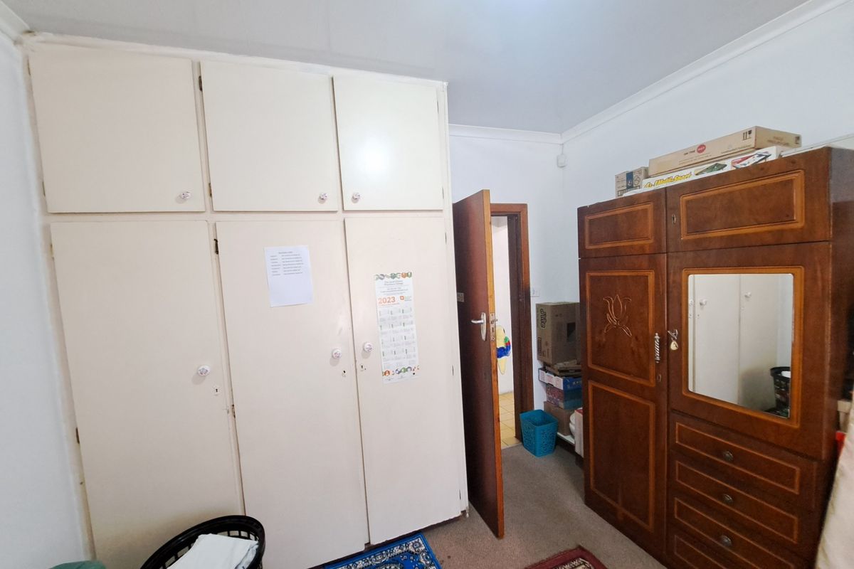 Bedroom featuring ample built-in cupboard storage and coved ceiling detailing.
