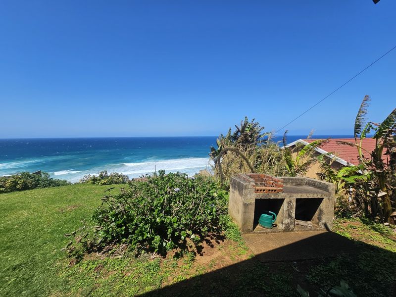Rear garden area featuring a built-in brick braai and expansive ocean views.