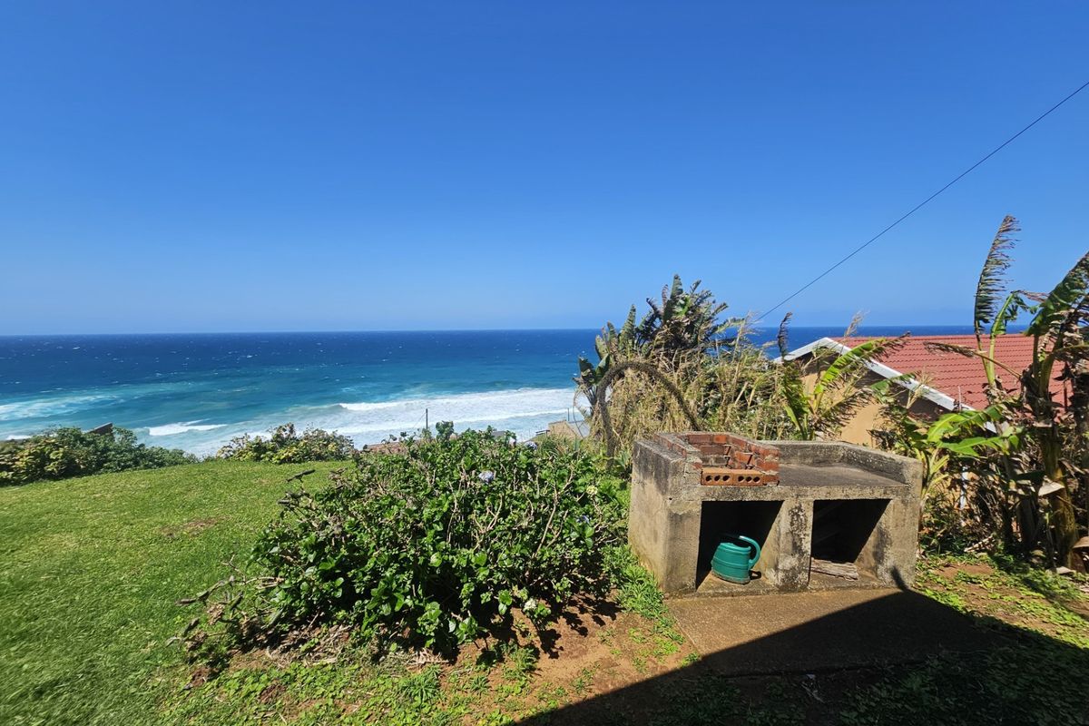 Rear garden area featuring a built-in brick braai and expansive ocean views.