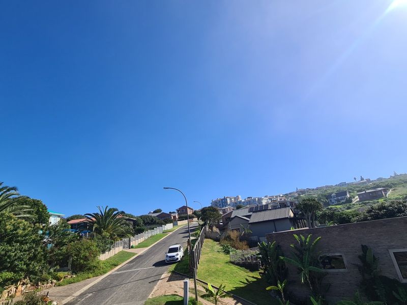 A view of the residential street and surrounding neighborhood landscape, showcasing the local road infrastructure and established residential properties.