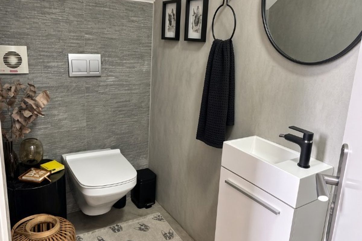 Modern guest bathroom featuring a wall-mounted toilet with concealed cistern, sleek vanity unit with basin, and contemporary grey tiled finishes.
