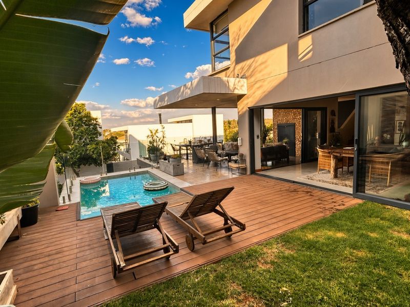 Modern townhouse exterior featuring a swimming pool, timber decking, and a covered patio area with seamless indoor-outdoor flow through large sliding glass doors.