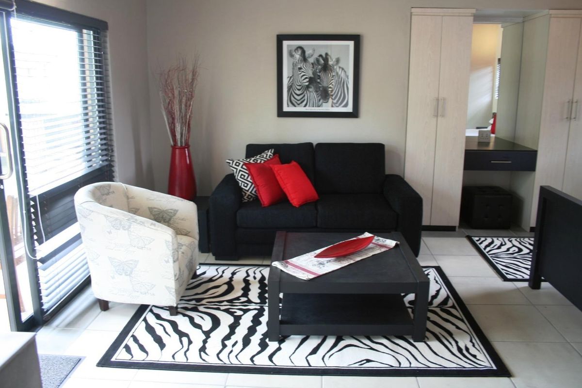 A well-maintained living area featuring tiled flooring, built-in wardrobe storage, and venetian blinds, offering a functional and tidy space.