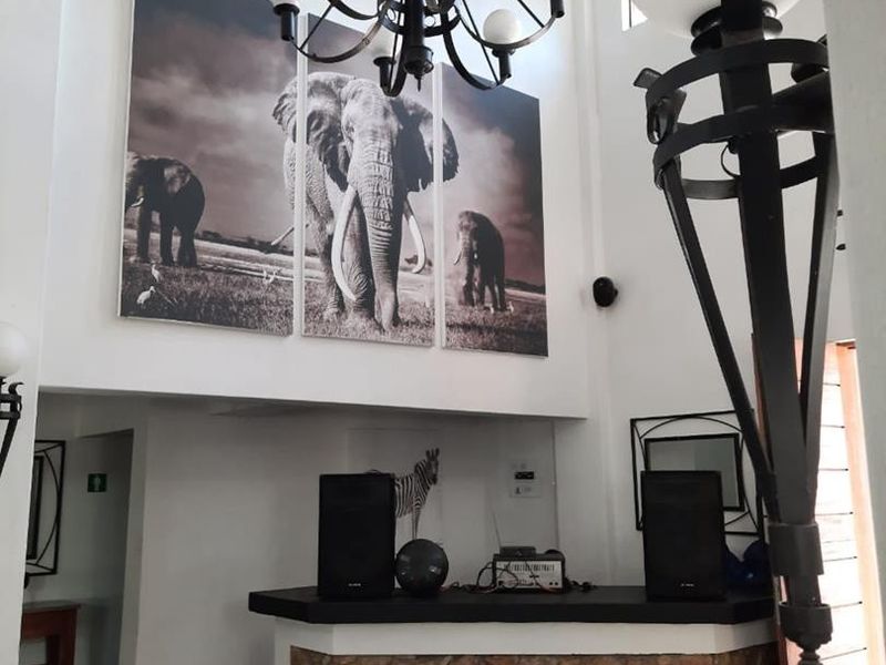 Entrance foyer featuring a stone-clad reception counter, high ceilings with exposed beams, and a decorative wrought iron chandelier.