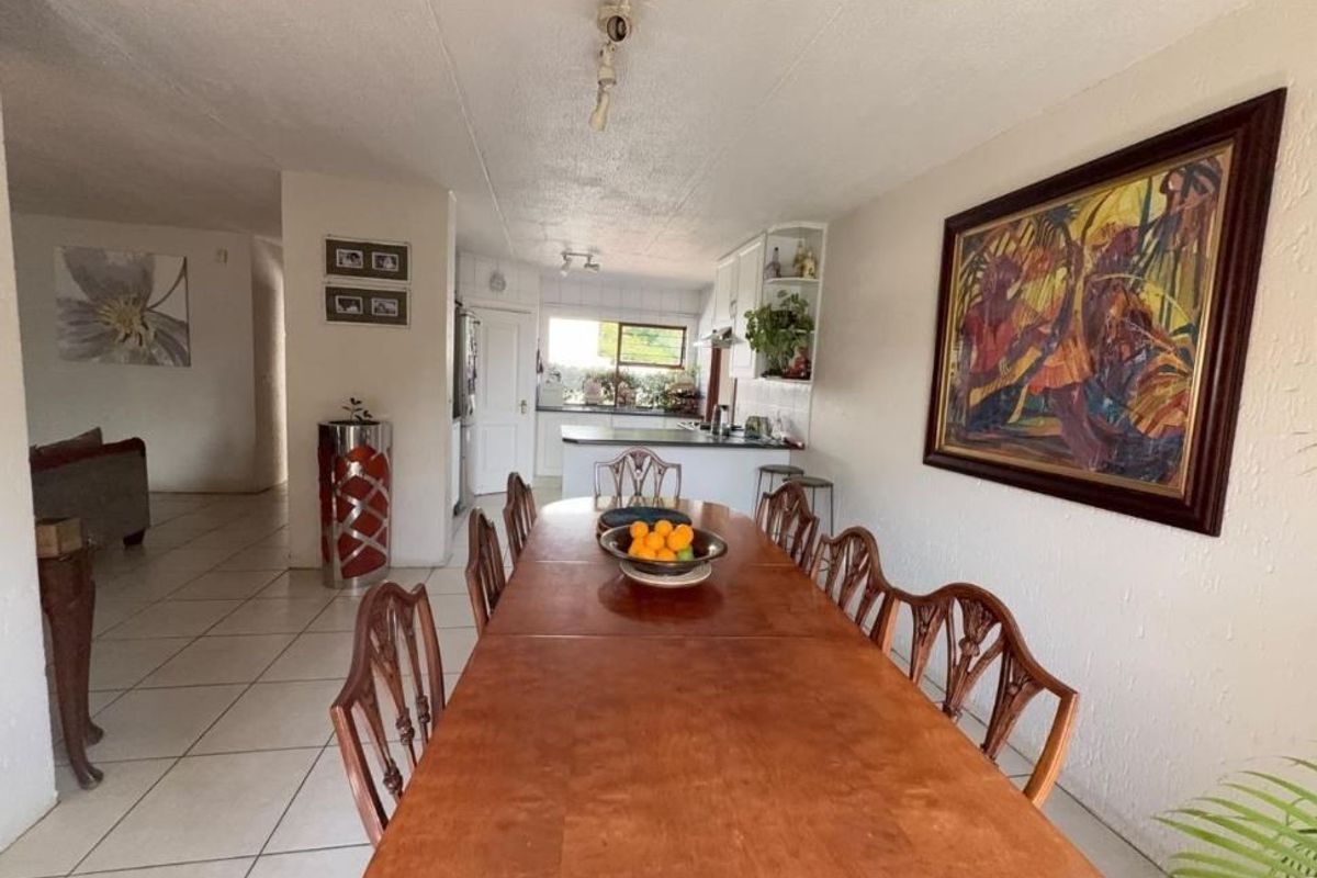 Open plan dining and kitchen area featuring tiled flooring and functional cabinetry, providing a connected living space.