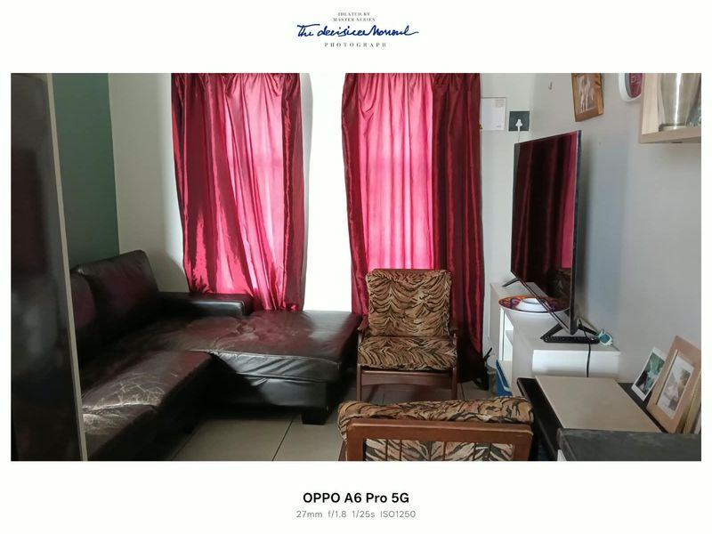 A compact living room area featuring tiled flooring and window treatments, providing a functional space for relaxation.