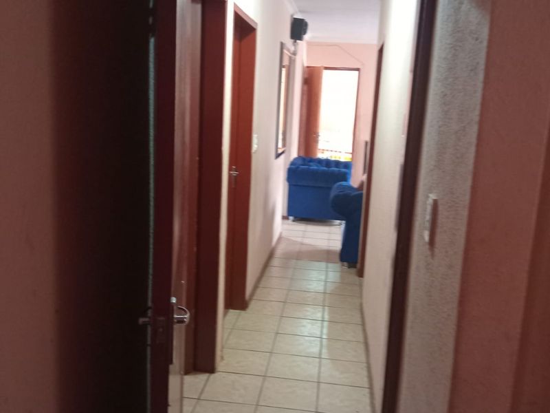 A functional interior hallway featuring tiled flooring and multiple internal door access points, connecting various rooms within the home.