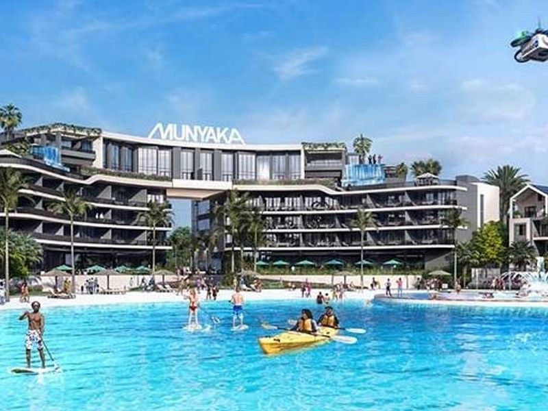 A wide-angle view of a large residential apartment complex featuring a central swimming pool and landscaped recreational area.