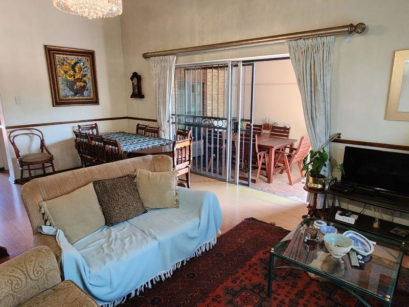 Open plan living and dining area featuring tiled floors, a staircase, and sliding glass doors leading to an outdoor patio space.