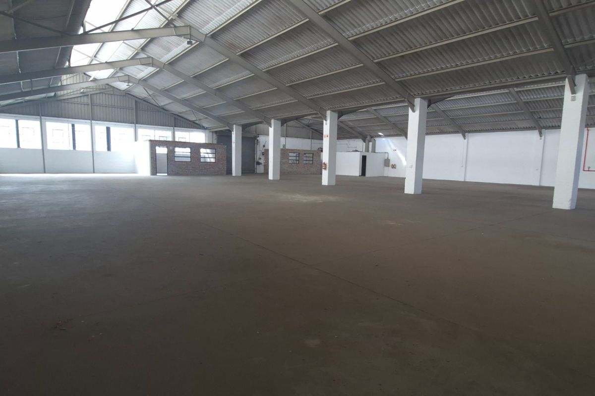 Spacious industrial warehouse featuring high ceilings, concrete flooring, and a robust steel portal frame structure, suitable for various storage or manufacturing operations.