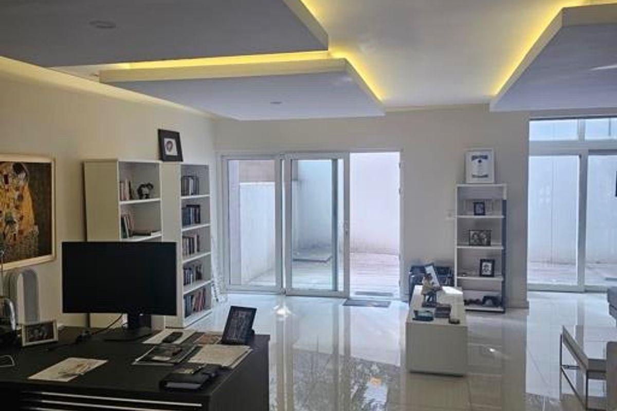 Modern living area featuring high-gloss floor tiles, sophisticated recessed ceiling design with integrated ambient lighting, and large sliding glass doors leading to the patio.
