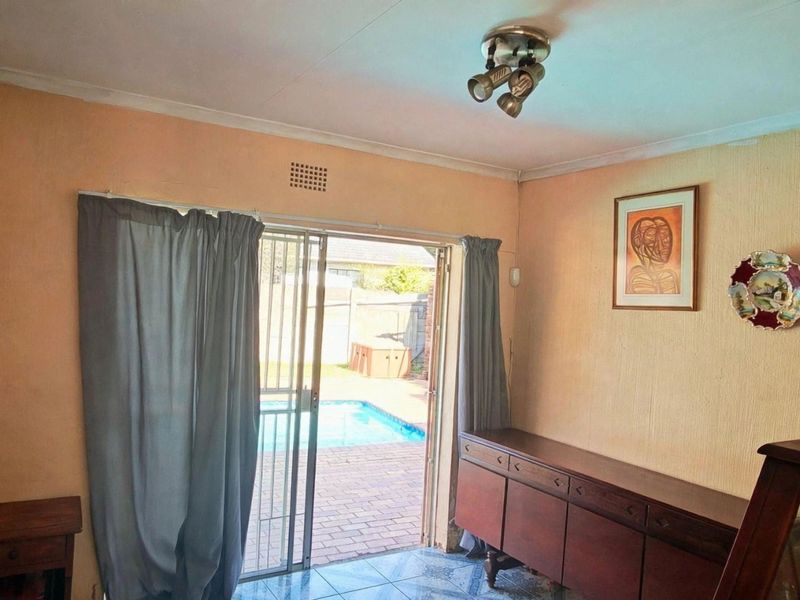 Living room featuring tiled flooring and a sliding glass door providing direct access to the outdoor pool area.