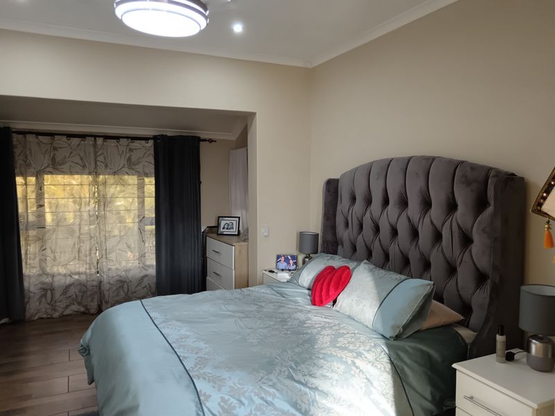 A well-maintained bedroom featuring tiled flooring, a recessed window area, and neutral wall tones, providing a comfortable and functional living space.