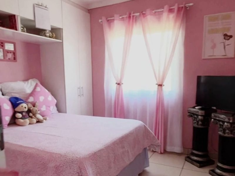 A bedroom featuring built-in cupboards and tiled flooring, offering a functional space with neutral base finishes.