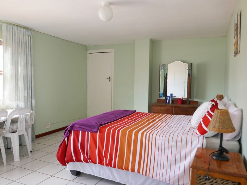 A bedroom featuring tiled flooring and neutral wall finishes, offering a functional space with natural light from the window.