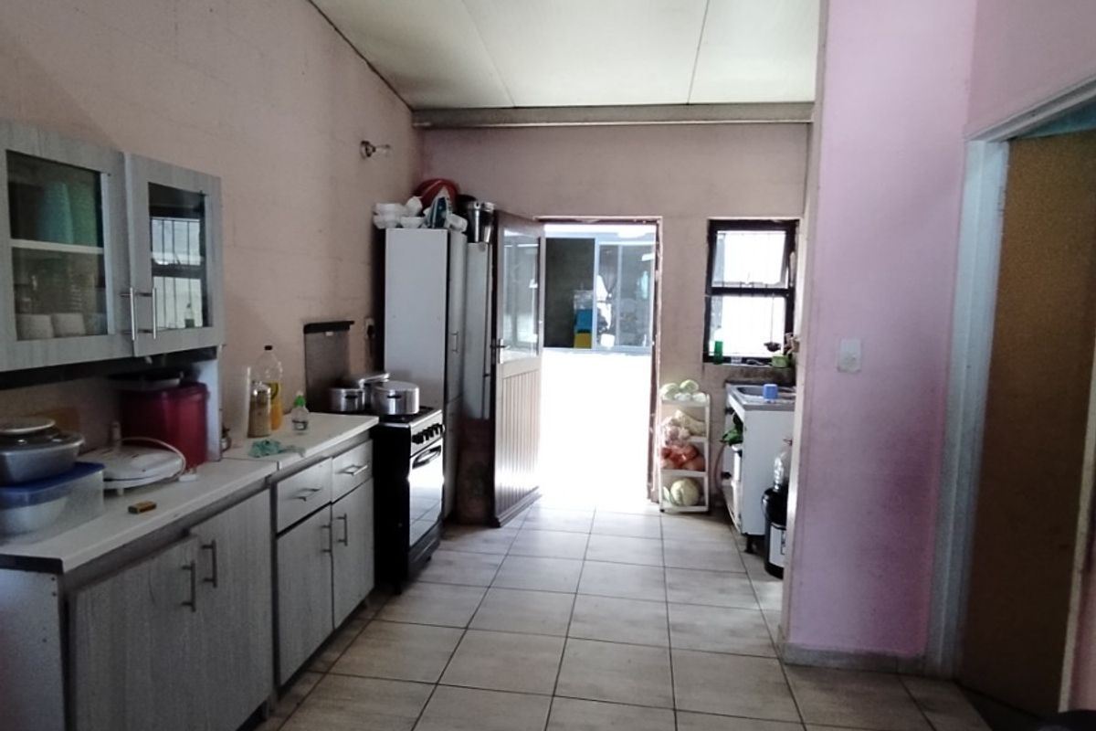 A functional kitchen space featuring tiled flooring, built-in cabinetry, and a stove, offering a practical layout with direct access to the exterior.