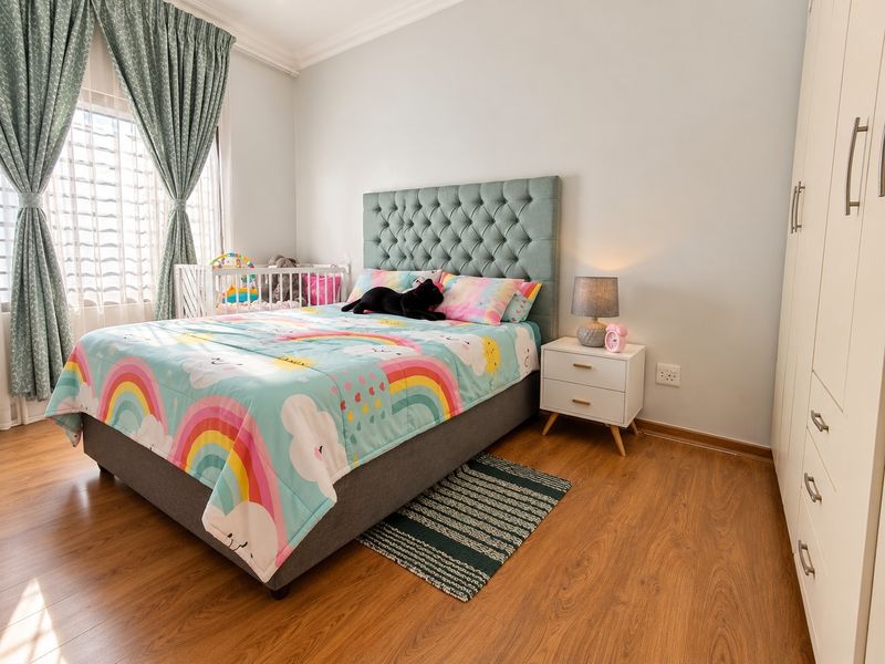 A well-maintained bedroom featuring laminate flooring, a built-in wardrobe, and decorative coving, offering a clean and functional living space.
