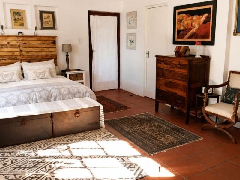 Spacious bedroom featuring traditional terracotta floor tiles and built-in recessed wall niches, offering a warm and rustic aesthetic.