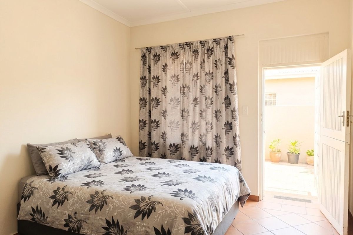 A bedroom featuring tiled flooring and direct access to an outdoor area through a private door.