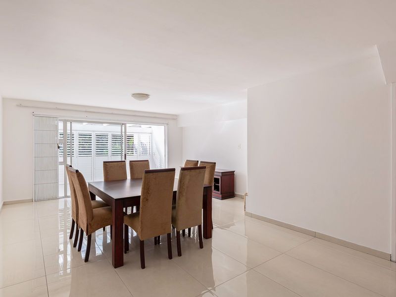 Bright dining area featuring large format floor tiles and sliding glass doors providing access to the outdoor space.