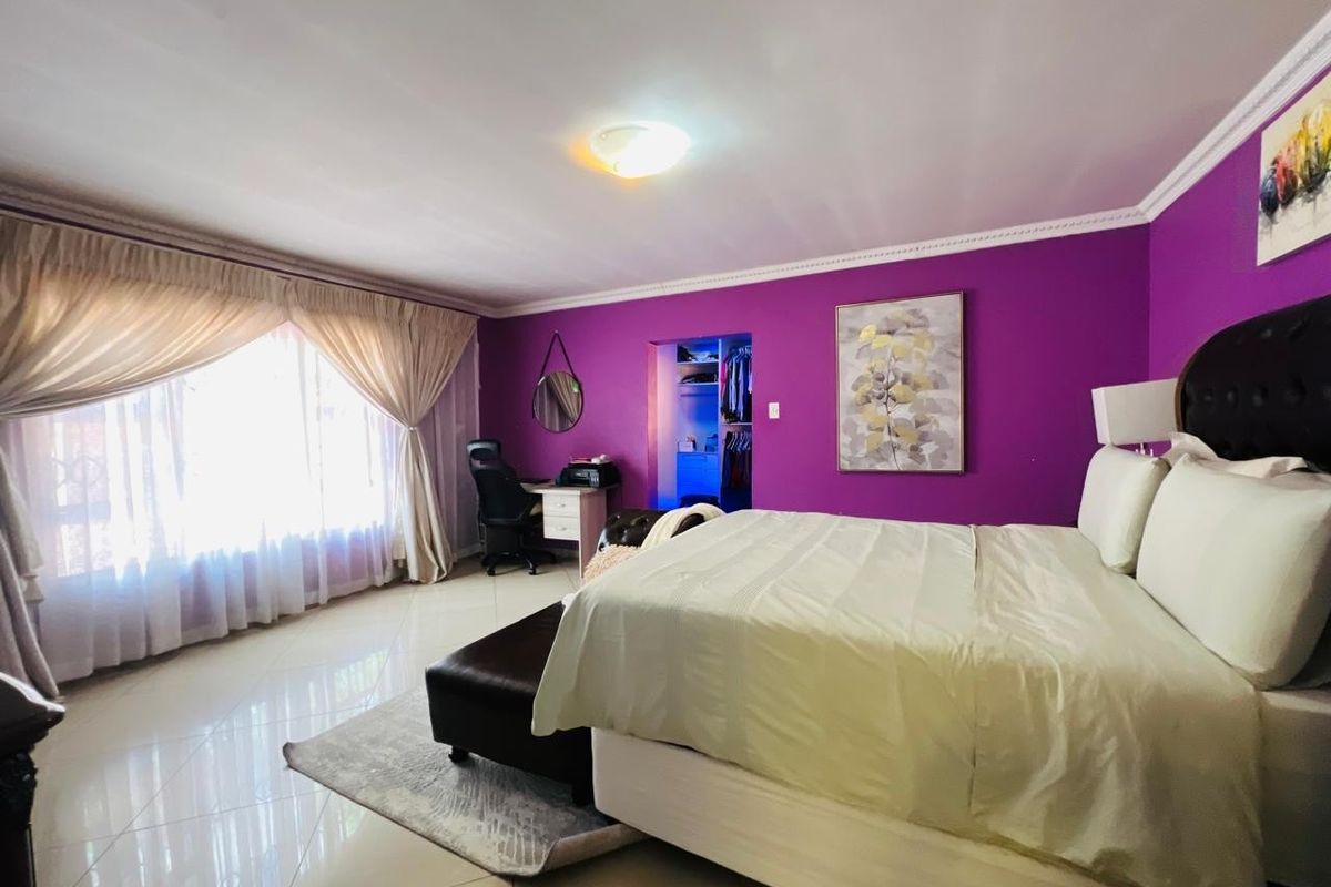 Spacious bedroom featuring tiled flooring, crown molding, and a built-in closet, offering a bright and functional living space.
