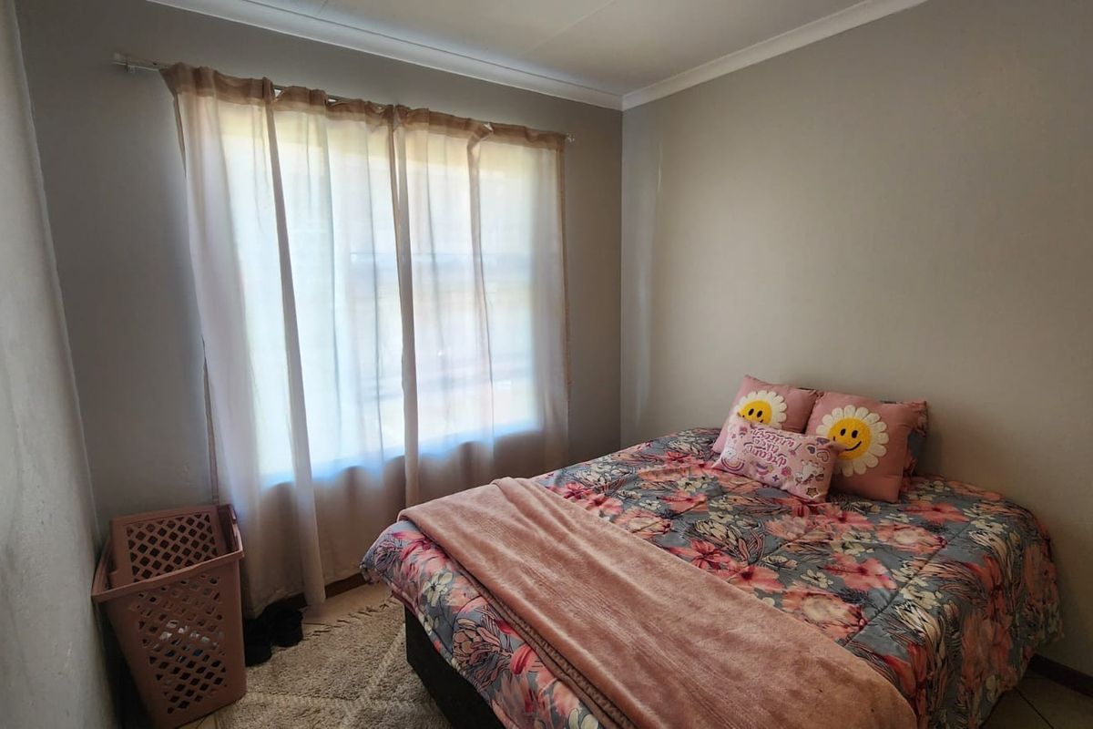 A standard bedroom featuring neutral wall finishes, coving, and a window with a curtain rod.