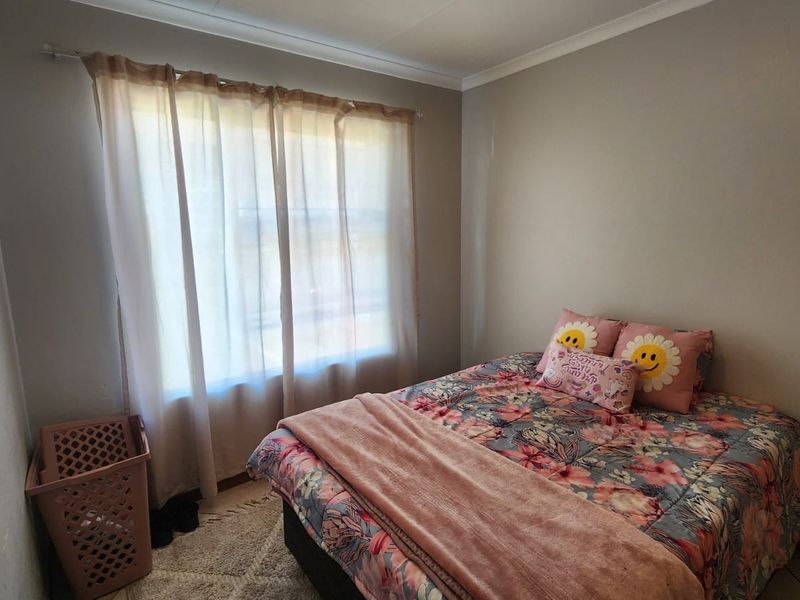 A standard bedroom featuring neutral wall finishes, coving, and a window with a curtain rod.