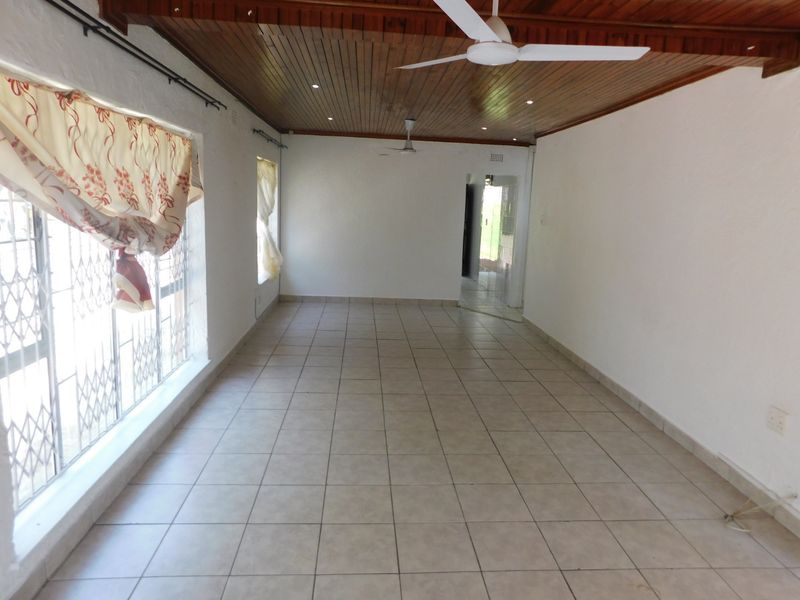 Spacious, empty living area featuring a timber tongue and groove ceiling, recessed lighting, ceiling fans, and ceramic tiled flooring.