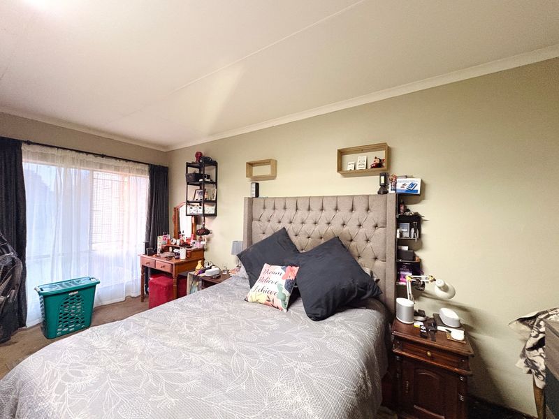 A standard bedroom featuring a sliding glass door with curtain tracks and coved ceiling detailing.