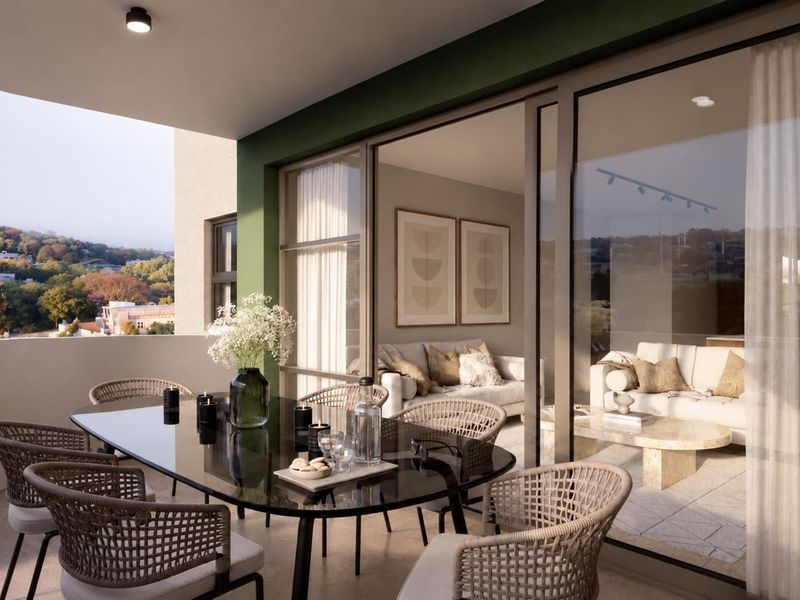 A modern covered balcony featuring sliding glass doors that connect to the interior living space, offering an elevated view of the surrounding landscape.