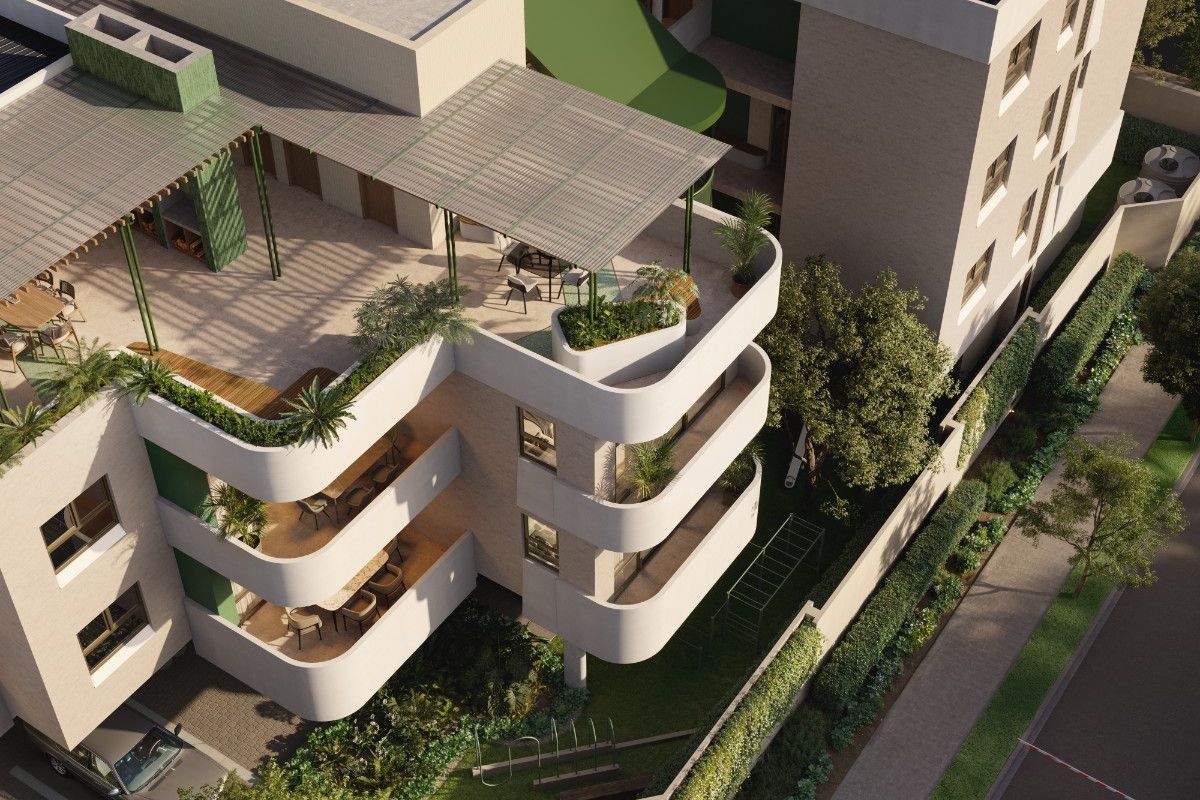 Aerial view of a modern apartment complex featuring tiered balconies, a rooftop terrace with pergola, solar panels, and landscaped ground-level gardens.
