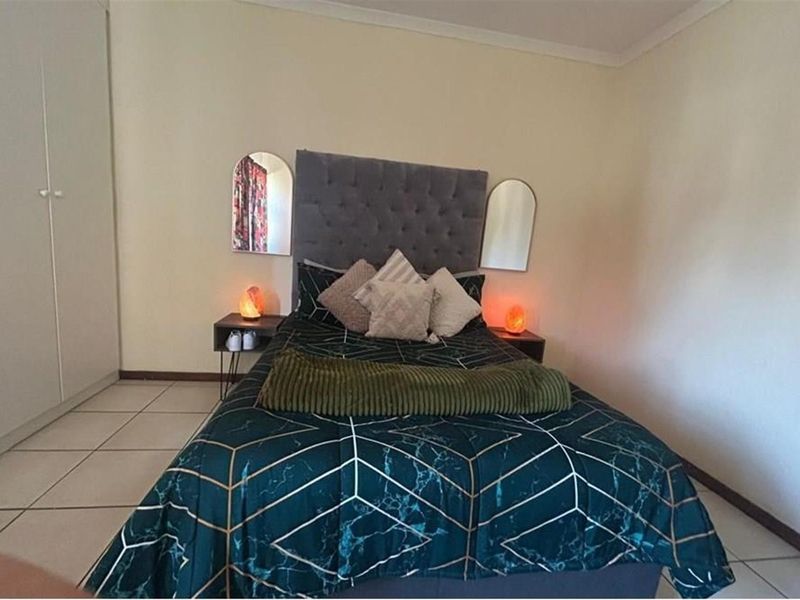A functional bedroom featuring tiled flooring and a built-in wardrobe, providing practical storage space within the townhouse.