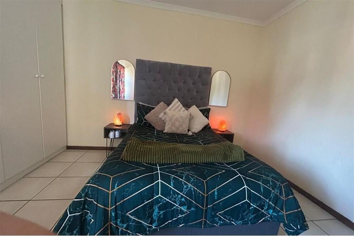 A functional bedroom featuring tiled flooring and a built-in wardrobe, providing practical storage space within the townhouse.