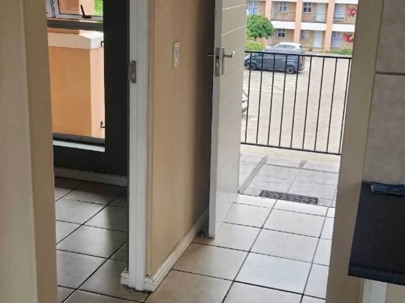Entryway featuring tiled flooring and direct access to an exterior balcony with metal railings, providing a functional transition space.