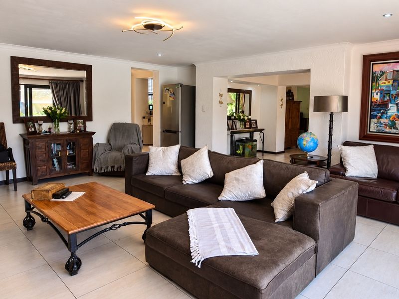 Spacious living room featuring neutral tiled flooring and recessed lighting, offering an open-plan layout with seamless flow into adjacent living areas.