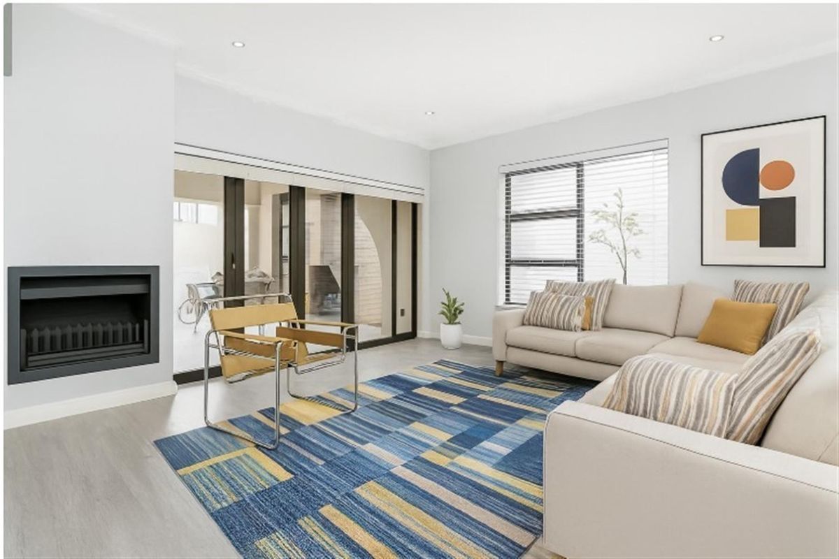 Bright and modern living room featuring a built-in fireplace, large sliding glass doors leading to the patio, and neutral finishes.