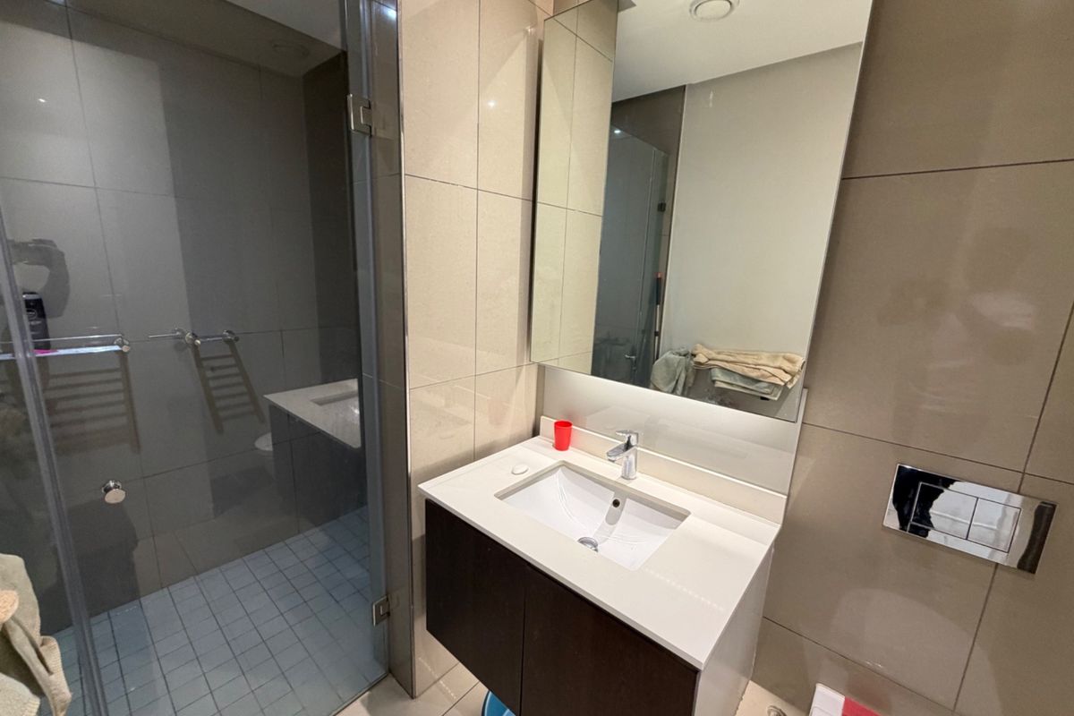 Modern bathroom featuring a wall-mounted vanity with integrated basin, frameless glass shower enclosure, and a wall-hung toilet with a concealed cistern.