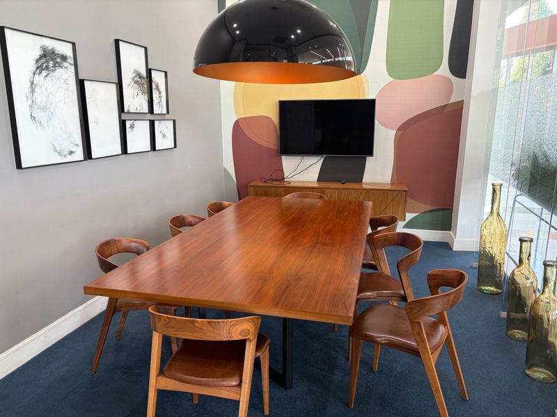 A well-appointed dining area featuring a statement feature wall, modern pendant lighting, and a spacious wooden dining table.