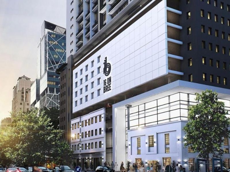 Modern high-rise commercial building facade featuring a prominent glass curtain wall and integrated branding at 16 on Bree.