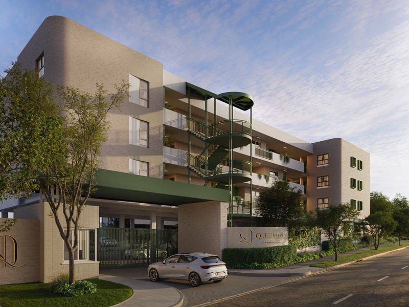 Modern apartment complex exterior featuring a secure gated entrance, architectural spiral staircase, and landscaped boundary wall.